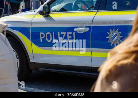 Nürnberg, 2. März 2025: Nahaufnahme der Beifahrerseite eines deutschen Polizeiwagens mit blauen und gelben Streifen und der Aufschrift „POLIZEI“. Stockfoto