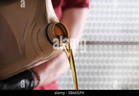 Mechaniker Mit Kanister Mit Motoröl, Das Aus Ihm Ausströmt Stockfoto