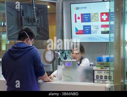 (250503) -- PEKING, 3. Mai 2025 (Xinhua) -- Ein Mann tauscht Banknoten an der Devisenbörse im Bahnhof Wangfujing der Pekinger U-Bahn-Linie 8 in Peking, Hauptstadt Chinas, 28. April 2025. China hat am 27. April ein neues Maßnahmenpaket zur weiteren Optimierung der Politik zur Erstattung der Abreisesteuer und zur Steigerung der Ausgaben für eingehende Reisen eingeführt. Zu den Maßnahmen, die vom Handelsministerium und fünf anderen Regierungsstellen angekündigt wurden, gehören die Senkung der Mindestbeschaffungsschwelle für Erstattungen, die Anhebung der Obergrenze für die Barrückerstattung, die Erweiterung des Netzes der teilnehmenden Geschäfte und die Erweiterung des Sortiments an Erzeugnissen Stockfoto