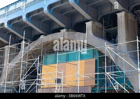 Städtische Brückeninstandhaltung mit umfangreichen Gerüst- und Reparaturarbeiten. Stockfoto