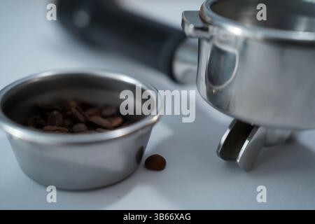 Portafilter, Kaffeebohnen und Barista-Werkzeuge auf weißem Hintergrund – perfekt für Espresso-Liebhaber und Cafés. Stockfoto