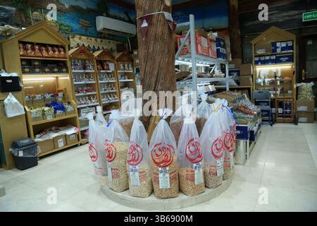 März 2022, Doha, Katar: Arabische Nüsse, Samen, Süßigkeiten und getrocknete Früchte in einem Geschäft im Gewürzsouq in Souq Waqif, Katar. Die Nüsse und Samen stammen hauptsächlich aus Indien und dem Iran und diese Artikel sind bei den Käufern sehr beliebt. Ein indischer Verkäufer stellt die Süßigkeiten im Geschäft aus. (Bild: © Sidhik Keerantakath/ZUMA Press Wire Service) Stockfoto