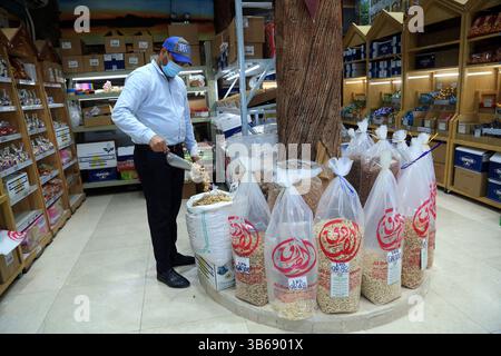 März 2022, Doha, Katar: Arabische Nüsse, Samen, Süßigkeiten und getrocknete Früchte in einem Geschäft im Gewürzsouq in Souq Waqif, Katar. Die Nüsse und Samen stammen hauptsächlich aus Indien und dem Iran und diese Artikel sind bei den Käufern sehr beliebt. Ein indischer Verkäufer stellt die Süßigkeiten im Geschäft aus. (Bild: © Sidhik Keerantakath/ZUMA Press Wire Service) Stockfoto