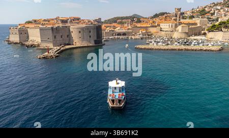 Touristenboot Segeln in der Nähe des alten Hafens von Dubrovnik. Aus der Vogelperspektive eines kleinen Bootes in der Adria in der Nähe der Stadt Kroatien Stockfoto