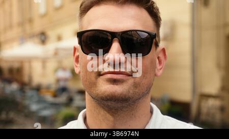 Nahaufnahme Porträt erfolgreicher Geschäftsmann Kaukasischer europäischer Mann stilvoller Mann selbstbewusst Sonnenbrille im Freien tragen männlicher Tourist Reisende Lächeln Wear Stockfoto