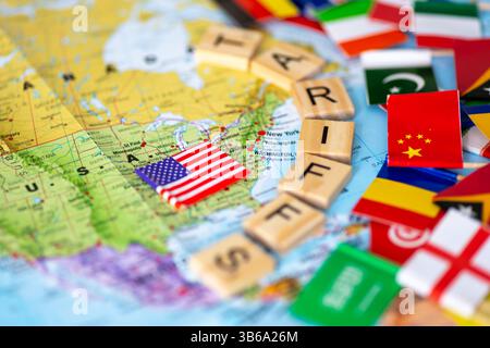 Eine Karte der USA und der amerikanischen Flagge, eingemauert durch Buchstaben Holzfliesen, die das Wort Zölle bilden, mit Flaggen anderer Länder außerhalb. USA Handel tari Stockfoto