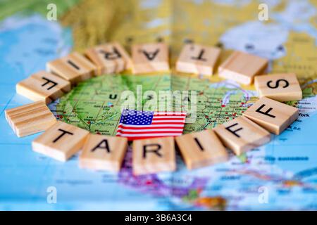 Buchstaben Holzfliesen, die die Worte „Zölle“ um eine Karte der Vereinigten Staaten von Amerika und die amerikanische Flagge herum bilden. Ein Konzept der US-Handelzölle. Stockfoto