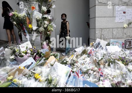 12. September 2022, HONGKONG, CHINA: Eine junge Frau hält inne und bestaunt das Blumenmeer vor dem britischen Generalkonsulat in Hongkong, während sie sich anstellt, um in das Generalkonsulat einzutreten, um das Kondolenzbuch zu unterschreiben.19.September 2022Hongkong.ZUMA/Liau Chung-ren (Kreditbild: © Liau Chung-ren/ZUMA Press Wire) Stockfoto
