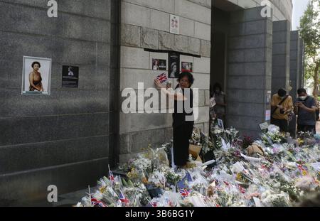 12. September 2022, HONGKONG, CHINA: Eine Frau ziert die Außenwand des britischen Generalkonsulats in Hongkong mit dem schwarzen Band, Porträts der verstorbenen Königin Elizabeth II. Und der kleinen Union Jack als Geste des Respekts für den britischen Souverän.Sept-12.2022Hong Kong.ZUMA/Liau Chung-ren (Kreditbild: © Liau Chung-ren/ZUMA Press Wire) Stockfoto