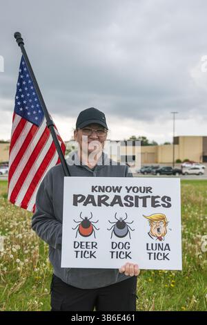 West Burlington, Iowa, USA. Mai 2025. Bürger der unteilbaren Iowa-Bewegung nahmen am 3. Mai 2025 an der Demonstration zum Nationalfeiertag in West Burlington, Iowa, USA, Teil. Eine Frau mit US-Flagge hielt ein Schild mit dem Aufdruck „kenne Yor Parasites“. Quelle: Keith Turrill/Alamy Live News Stockfoto