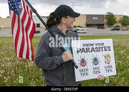 West Burlington, Iowa, USA. Mai 2025. Bürger der unteilbaren Iowa-Bewegung nahmen am 3. Mai 2025 an der Demonstration zum Nationalfeiertag in West Burlington, Iowa, USA, Teil. Eine Frau mit US-Flagge hielt ein Schild mit dem Aufdruck „kenne Yor Parasites“. Quelle: Keith Turrill/Alamy Live News Stockfoto