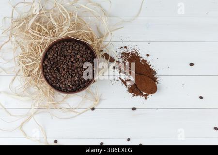 Einige Kaffeebohnen mit gemahlenem Kaffee in einer Schüssel auf hölzernem Hintergrund, Blick von oben. Stockfoto