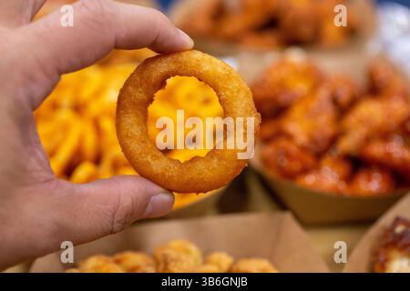 Eine Nahaufnahme einer Hand, die einen Zwiebelring hält. Stockfoto