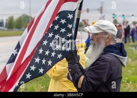 West Burlington, Iowa, USA. Mai 2025. Bürger der unteilbaren Iowa-Bewegung nahmen am 3. Mai 2025 an der Demonstration zum Nationalfeiertag in West Burlington, Iowa, USA, Teil. Ein Mann hielt eine US-Flagge auf dem Kopf, um gegen den gegenwärtigen Staat der Regierung zu protestieren. Quelle: Keith Turrill/Alamy Live News Stockfoto