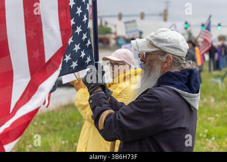 West Burlington, Iowa, USA. Mai 2025. Bürger der unteilbaren Iowa-Bewegung nahmen am 3. Mai 2025 an der Demonstration zum Nationalfeiertag in West Burlington, Iowa, USA, Teil. Ein Mann hielt eine US-Flagge auf dem Kopf, um gegen den gegenwärtigen Staat der Regierung zu protestieren. Quelle: Keith Turrill/Alamy Live News Stockfoto