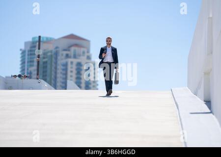 Reicher Geschäftsmann, der draußen läuft. Erfolgreicher Geschäftsmann mit Aktentasche. Führungskraft in Bewegung. Geschäftsmann geht selbstbewusst. Geschäftsmann in A Stockfoto