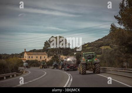 19. Februar 2024, Mahon, Menorca / Balearen, Spanien: Landwirte mit ihren Traktoren fahren im Schneckentempo auf Menorcas ME-1, der Rückgrat-Straße der Inseln, mit ihren Traktoren, um gegen die europäische Agrarpolitik, steigende Kosten, sinkende Einnahmen und unlauteren Wettbewerb aus Drittstaaten zu protestieren und sich den Protesten von EU-Kollegen anzuschließen. (Foto: © Matthias Oesterle/ZUMA Press Wire) Stockfoto