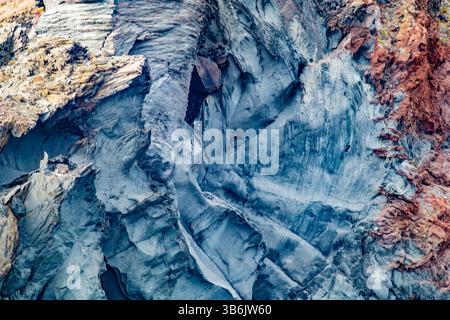 Steigung der Felsformation mit rauen Mustern auf der Oberfläche der Felswand, Kombination aus blauen, grauen, roten und gelben Farben, Coronado Island in Loreto Bay N Stockfoto