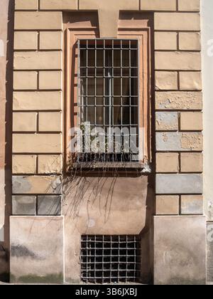 Cremona, Italien - 12. April 2025 Geometrisches Fensterdesign mit Metallstäben und Ziegelwerk, eine Kombination aus architektonischen Elementen und Materialien Crea Stockfoto