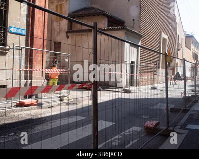 Cremona, Italien – 12. April 2025 Aufnahme eines Straßenbauprojekts mit Gerüstkonstruktion und Fußgängerbarrieren in städtischer Umgebung Stockfoto