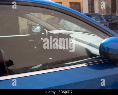 Cremona, Italien - 12. April 2025 durch das Fenster des Fahrzeugs mit Blick auf das Armaturenbrett im Innenraum mit Instrumententafel und Rückspiegel eines Fahrzeugs in der Ur Stockfoto