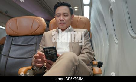 Passagier Geschäftsmann mit Handy Test wifi Verbindung im Flugzeug während des Fluges Stockfoto