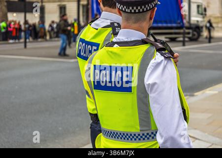 Polizist in gut sichtbarer Weste im Dienst im städtischen Straßenumfeld Stockfoto