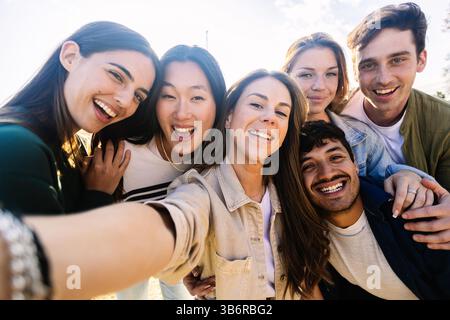 Junge Gruppe glücklicher Menschen, die draußen ein Selfie-Porträt machen Stockfoto