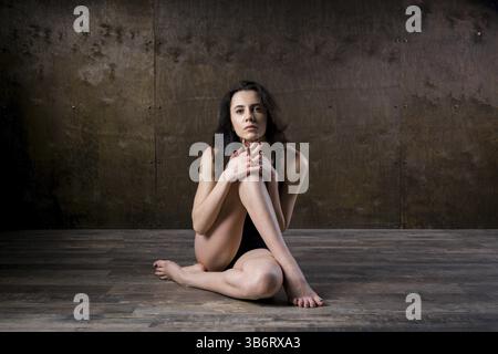 Abstraktes und stressgefühlvolles Konzept. Depressives Mädchen in einsamer Stimmung, Thema des Stresses. Traurige Frau, die allein in leerem Zimmer sitzt. Depression und Chronik Stockfoto