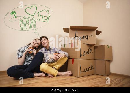Ein junges Paar mit Kisten Kaffee in der neuen Wohnung Stockfoto