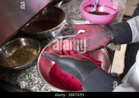 Thema kochen Pralinen Trüffel. Close-up Hand jungen kaukasischen Frau und Mann Kochen mit Tattoo und in Uniform bereitet, macht Runde balltake der Süße Stockfoto