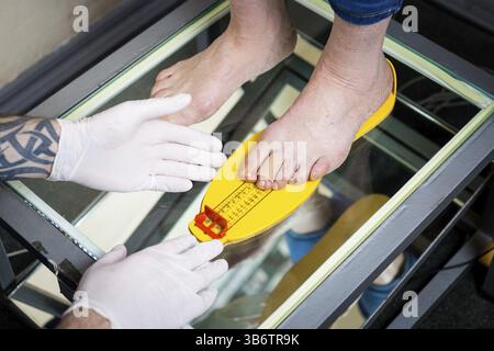 Orthopdie und Medizin. Junge kaukasier Arzt Hnde Mann tattoo Latex  Handschuhe Gre Messung Form des Fues fr die Herstellung von Einzelnen  oder Stockfotografie - Alamy