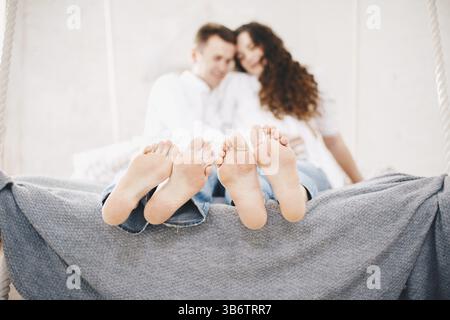 Nahaufnahme männlicher und weiblicher Beine. Das liebende Paar liegt auf dem Bett unter der Decke Stockfoto