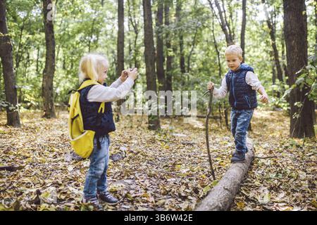 Kinder im Vorschulalter kaukasischen Bruder und Schwester Bilder von einander auf Handy Kamera in Forest Park Herbst. Thema der Hobby- und Aktiv Stockfoto