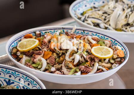 Insalata di Mare, italienischer Salat mit Meeresfrüchten auf einer Keramikplatte. Italiens klassischer, heller Salat aus sanft gekochten und marinierten Meeresfrüchten mit Zitrone Stockfoto