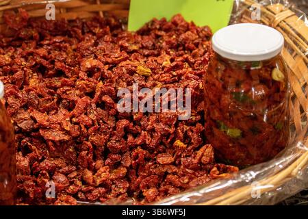 Frische Bio-rote, reife Kirschtomaten in einem Korb mit einem Glas auf einem Straßenmarkt, Nahaufnahme Stockfoto