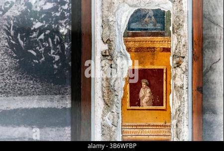 Aus nächster Nähe eine alte Mauer mit teilweise freiliegendem Fresko, mit lebhaften Farben und komplizierten Details. Die Umgebung zeigt Weader Stockfoto