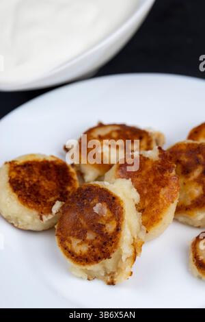 Hausgemachte kleine Käsekuchen Pfannkuchen aus Hüttenkäse Pfannkuchen mit Sauerrahm Stockfoto
