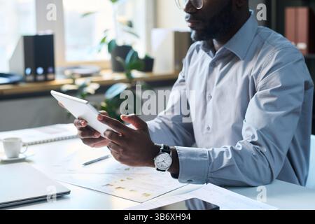 Schwarzer Mann mit digitalem Tablet bei der Arbeit Stockfoto
