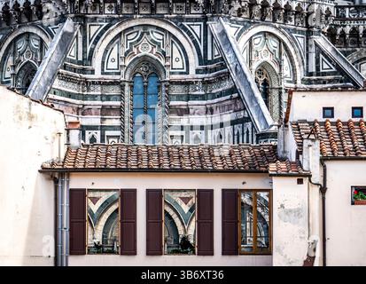 Eine Nahaufnahme der architektonischen Details mit komplexen Mustern und Entwürfen eines historischen Gebäudes, mit einer Reflexion im Fenster eines nahegelegenen Stockfoto
