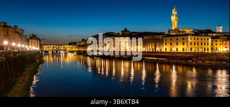 Ein atemberaubender Blick in die Dämmerung von Florenz, Italien, mit Blick auf den Fluss Arno, der die Lichter der Stadt reflektiert. Die Ponte Vecchio Brücke und historische Gebäude sind Stockfoto