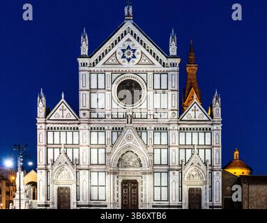 Ein atemberaubender Blick auf die Basilika di Santa Croce in Florenz, Italien, bei Nacht beleuchtet. Die komplizierte Fassade ist mit gotischer Architektur und weiß dekoriert Stockfoto