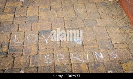 Kinder zeichneten die Worte Liebe, entspringen auf dem Bürgersteig mit farbigen Kreiden Stockfoto
