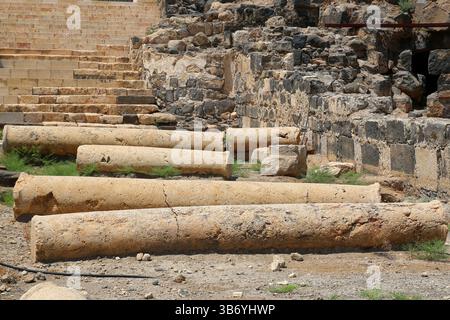 Eingestürzte römische Säulen zwischen Ruinen in der archäologischen Stätte von Beit She’an, Israel, die alte seismische Schäden oder Verfall über Jahrhunderte zeigen. Stockfoto