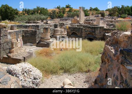 Steinsäulenbasen und römische Mauerwerke an der archäologischen Stätte Beit She’an in Israel, die Basaltblöcke und verwitterten Kalkstein zeigen. Stockfoto