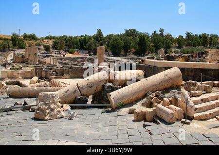 Eingestürzte römische Säulen zwischen Ruinen in der archäologischen Stätte von Beit She’an, Israel, die alte seismische Schäden oder Verfall über Jahrhunderte zeigen. Stockfoto