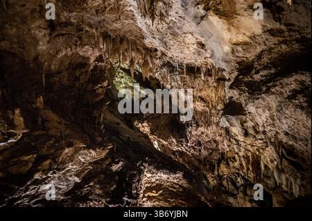 Aus nächster Nähe sehen Sie das Innere einer Höhle mit komplexen Felsformationen, Stalaktiten und unterschiedlichen Texturen der Höhlenwände. Die Beleuchtung wird hervorgehoben Stockfoto