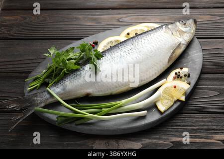 Gesalzener Hering und Gewürze auf Holztisch Stockfoto