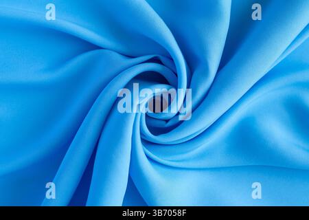 Nahaufnahme aus leuchtend blauem Material mit kreativen Falten und einzigartigen Texturen Stockfoto
