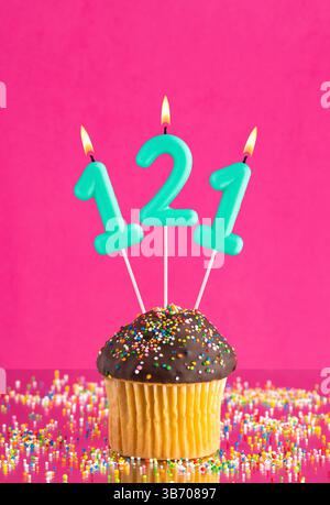 Geburtstagskuchen mit der Zahl 121 Kerze - Geburtstagskarte auf Fuchsia Hintergrund Stockfoto